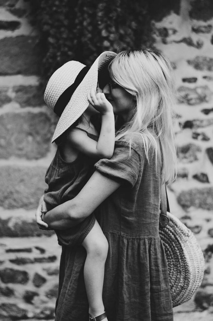 single mom holding her child. Emotionally healthy adults feel connected. Often overwhelmed single mothers need support. These are heroic single mothers raising children.