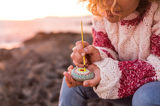 Woman painting a design on a rock