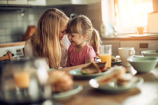 Woman has busy kitchen. Taking a moment to enjoy her daughter.
